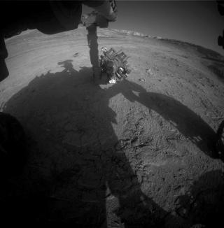 Манипулятор Curiosity во время работы перед заходом Солнца на Марсе.