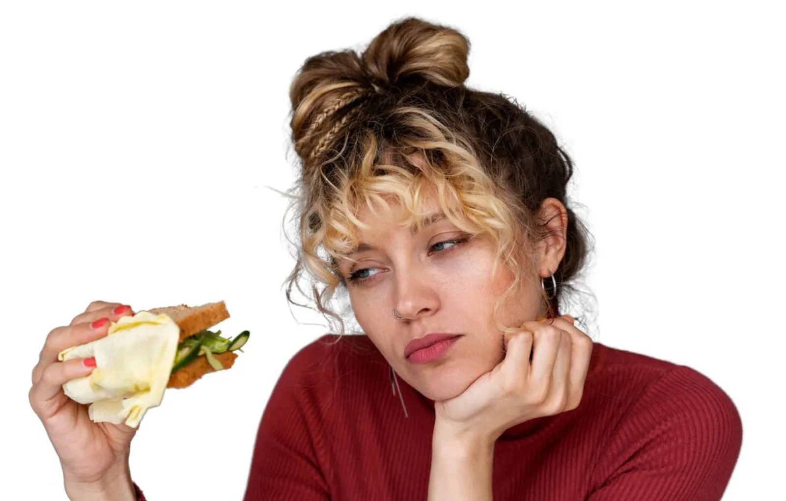 Девушка смотрит на сэндвич.