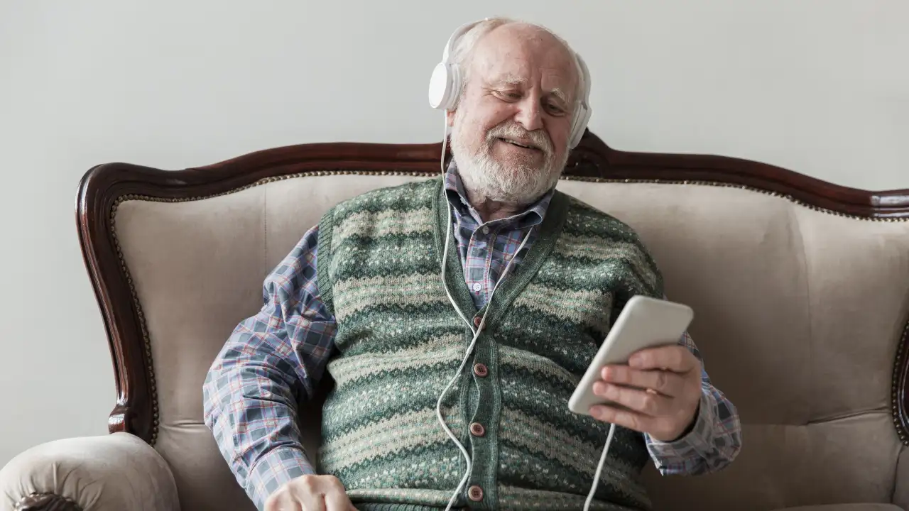 Пожилой человек слушает музыку.