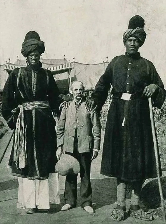 Два кашмирских гиганта позируют рядом с американским фотографом Джеймсом Рикалтоном, 1903 год.