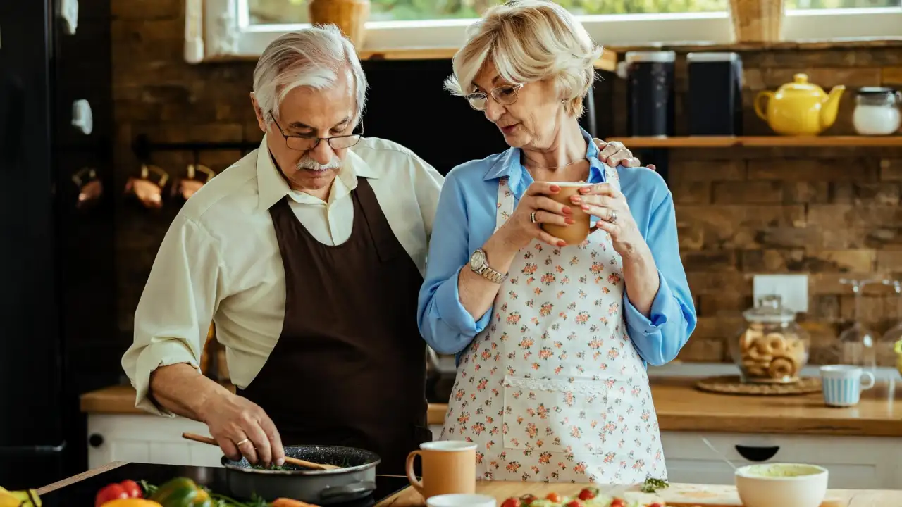 Пожилая пара готовит.