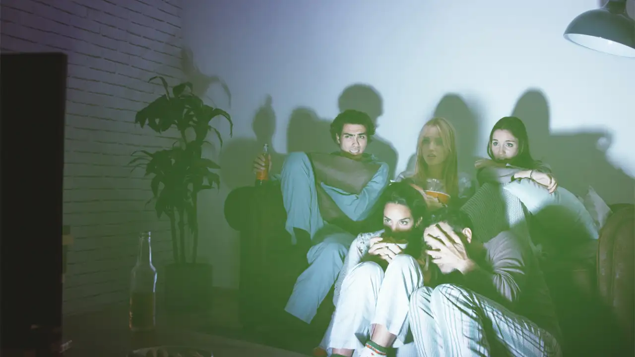 Группа ребят смотрят фильм ужасов.