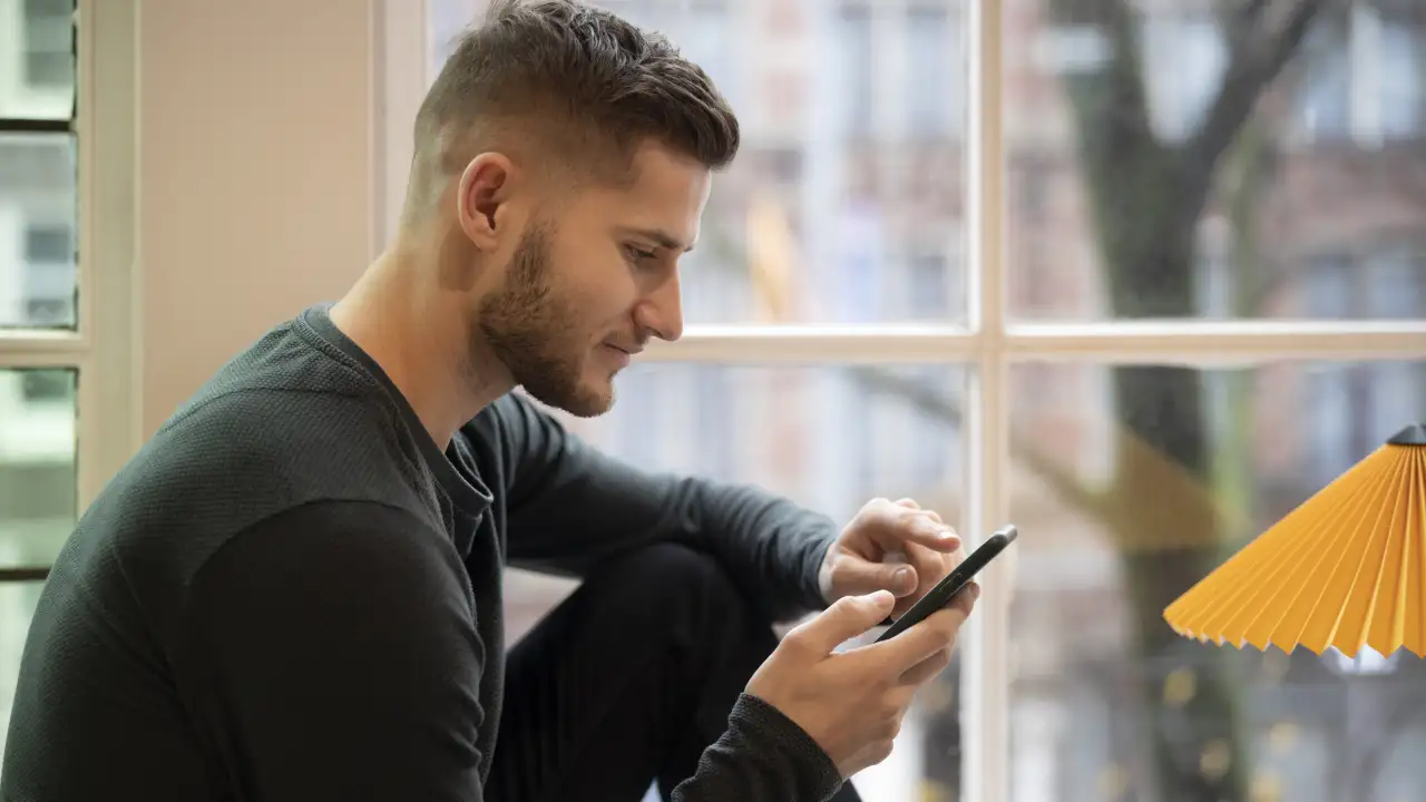 Мужчина смотрит в телефон. 