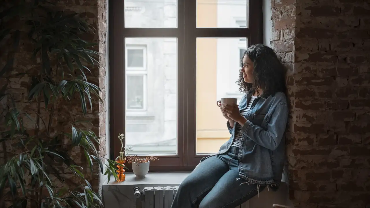 Человек сидит у окна.