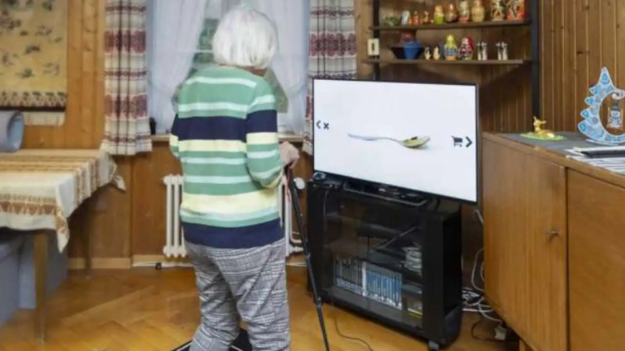 Пожилая женщина играет в фитнес-игру. 