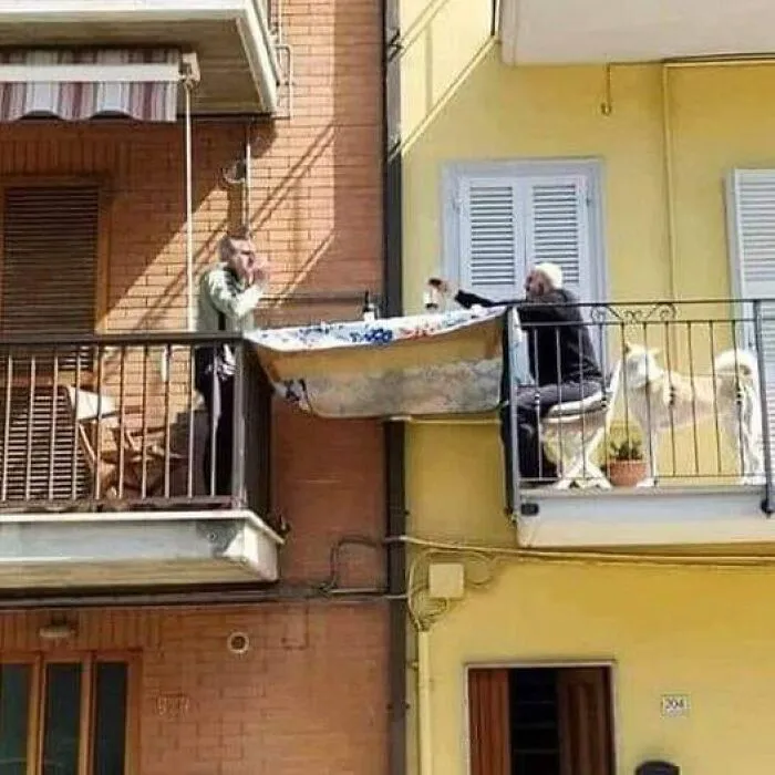 Эти два итальянца установили столик между своими балконами, чтобы насладиться совместным ужином.